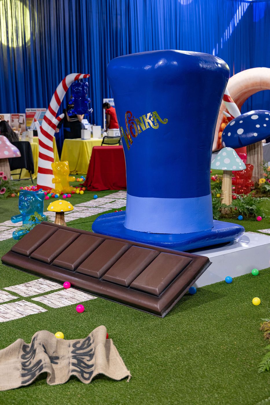 A giant top hat and chocolate bar prop on an artificial lawn