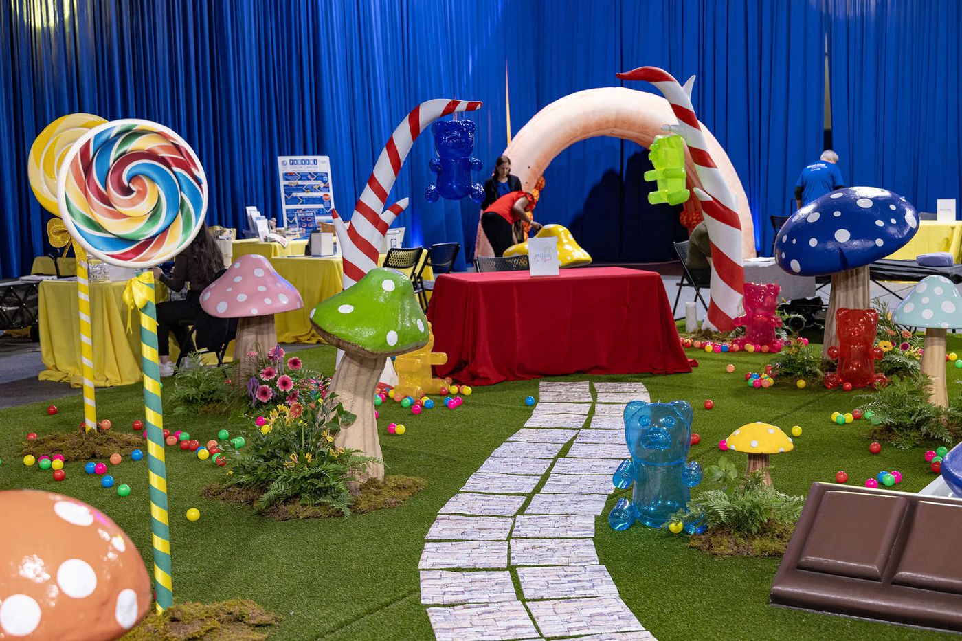 A path of oversized lollipops and candy props laid across an event floor