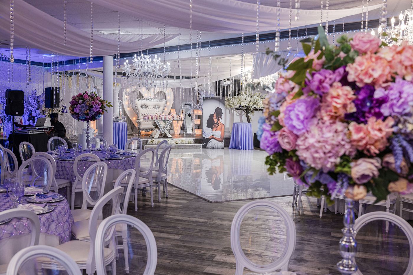 A sweet sixteen ballroom dressed in lavender and silver with towering floral centrepieces