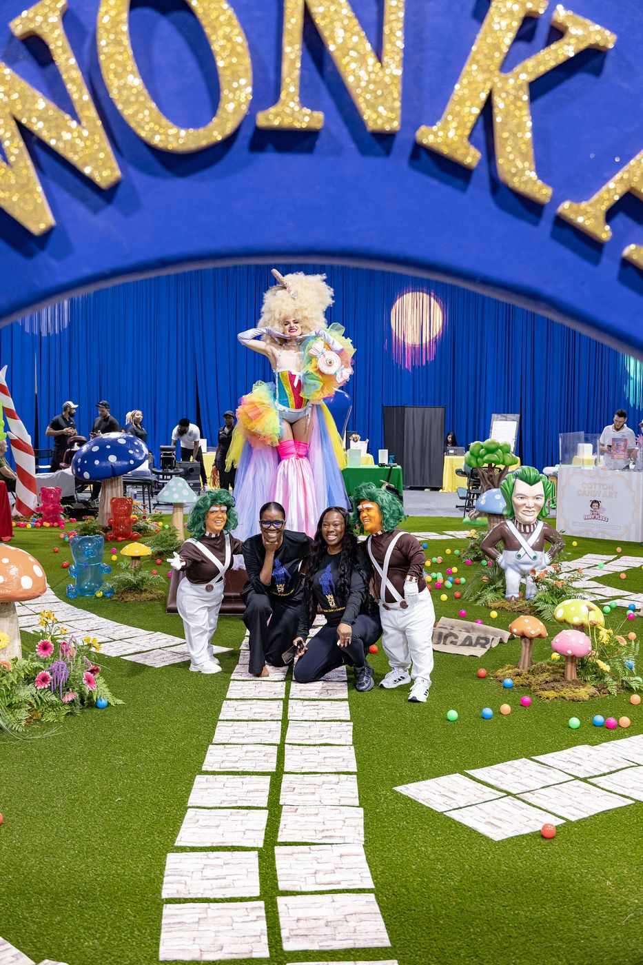 The event team photographed together beneath the entrance arch of their build