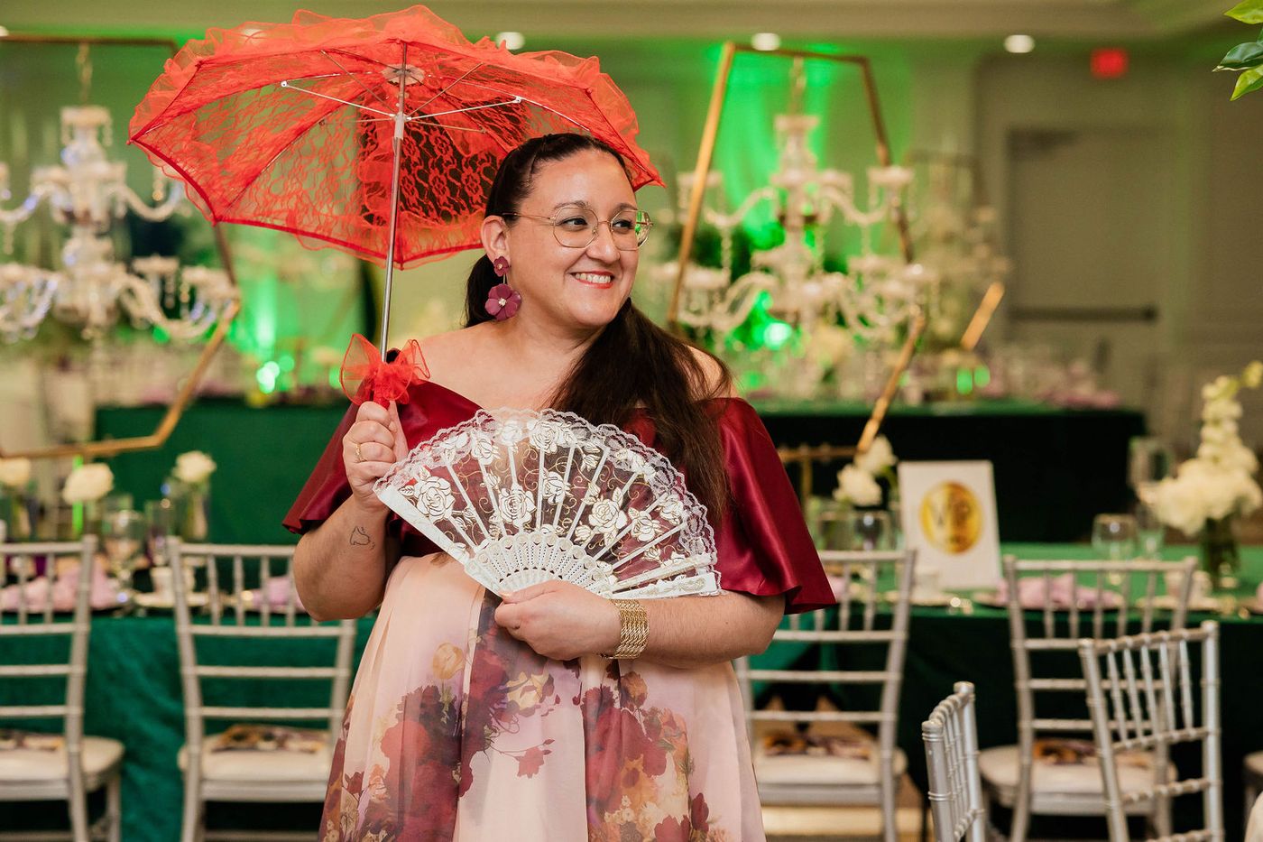 A guest with a red parasol and feathered fan in Regency dress