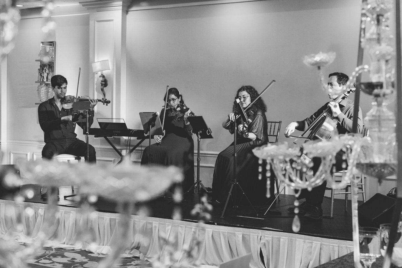 A black and white frame of the string quartet during dinner