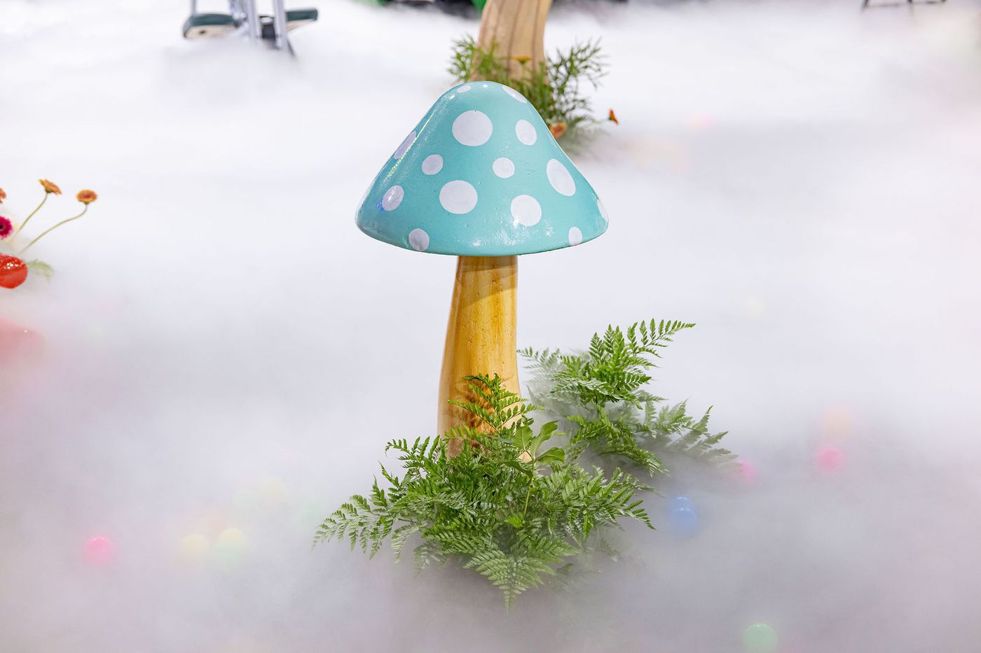 Oversized toadstools standing in a drift of low fog on an event floor