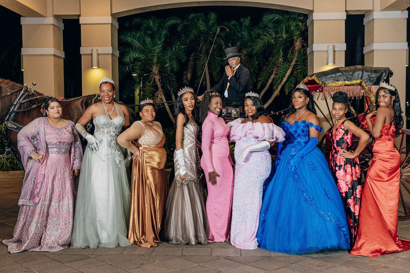 A line of guests in full period ball gowns across the dance floor