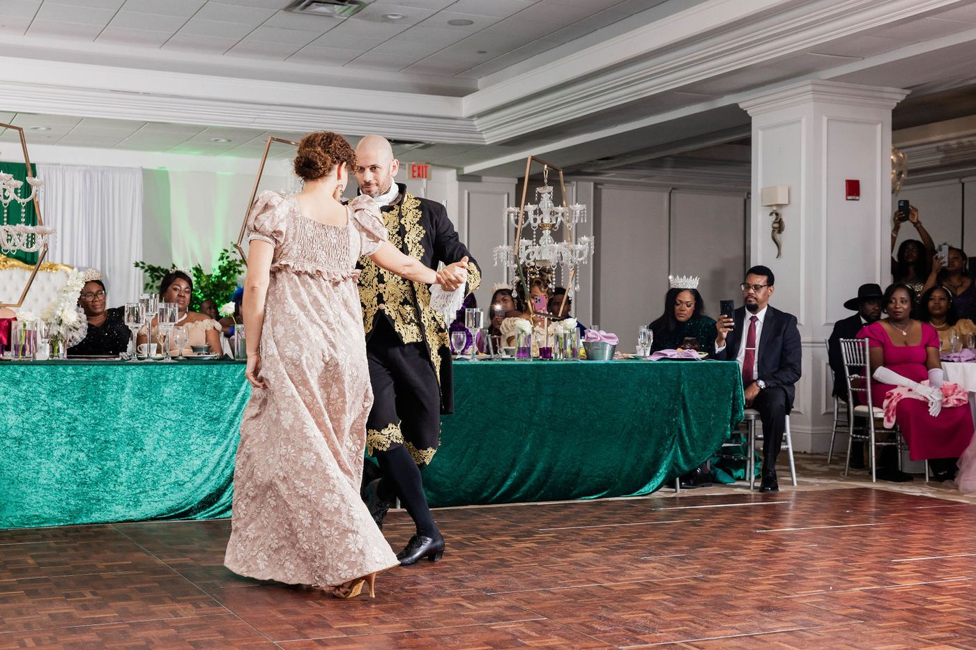 Guests dancing in period costume on the floor of a Regency ball