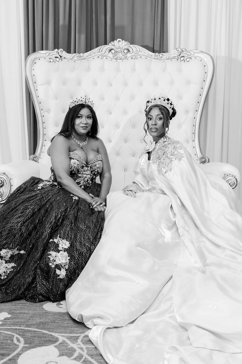A black and white throne portrait of two guests in court dress