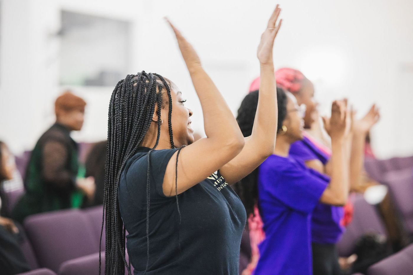 Members of the congregation in worship with raised hands
