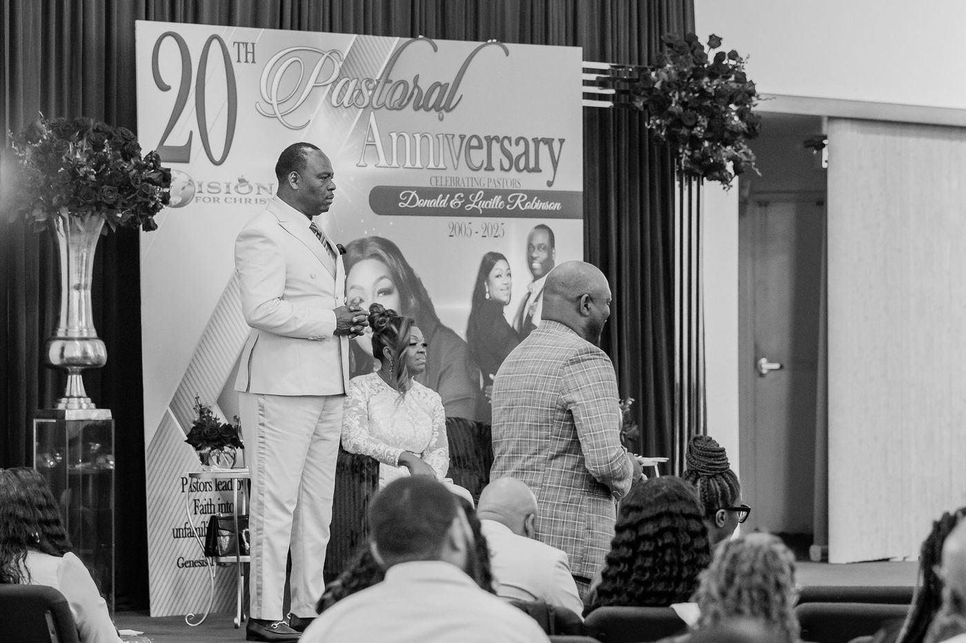 A black and white frame from the platform of a pastoral anniversary service
