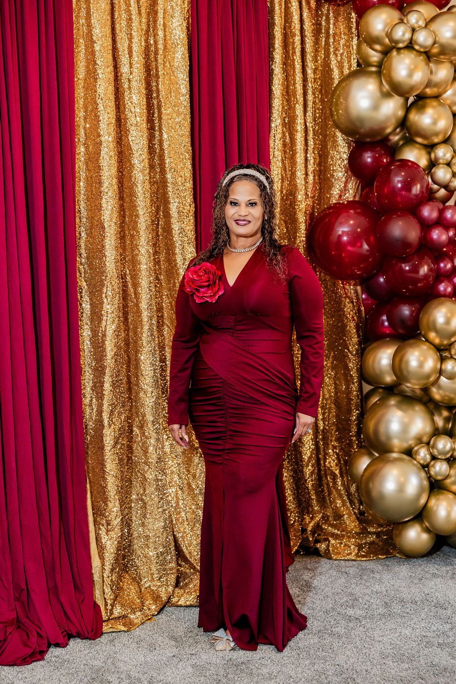 A guest in a red gown at the 20th pastoral anniversary portrait backdrop