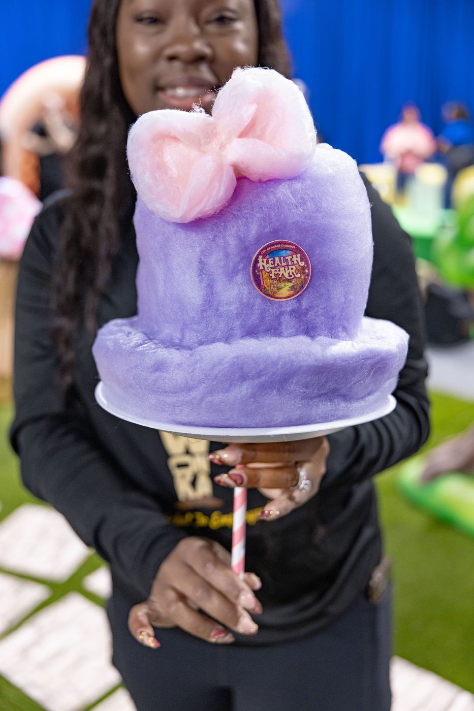 A guest holding a sculpted cotton candy creation at a family event