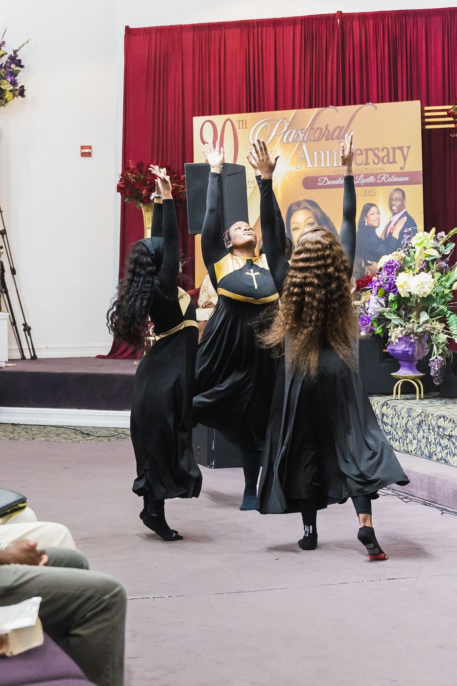 A liturgical dancer mid-movement during a pastoral anniversary service