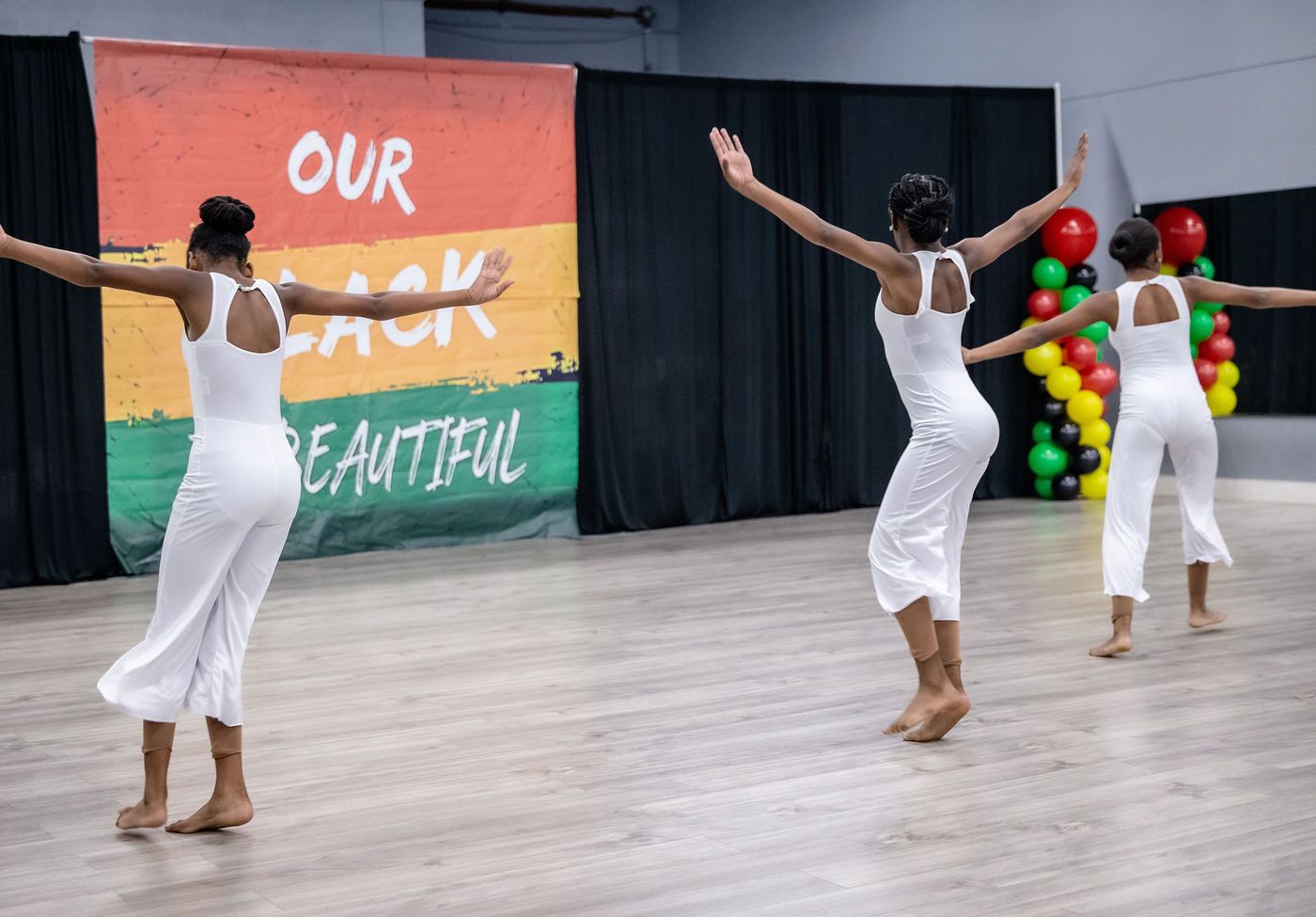A dancer in white performing at a Black History showcase