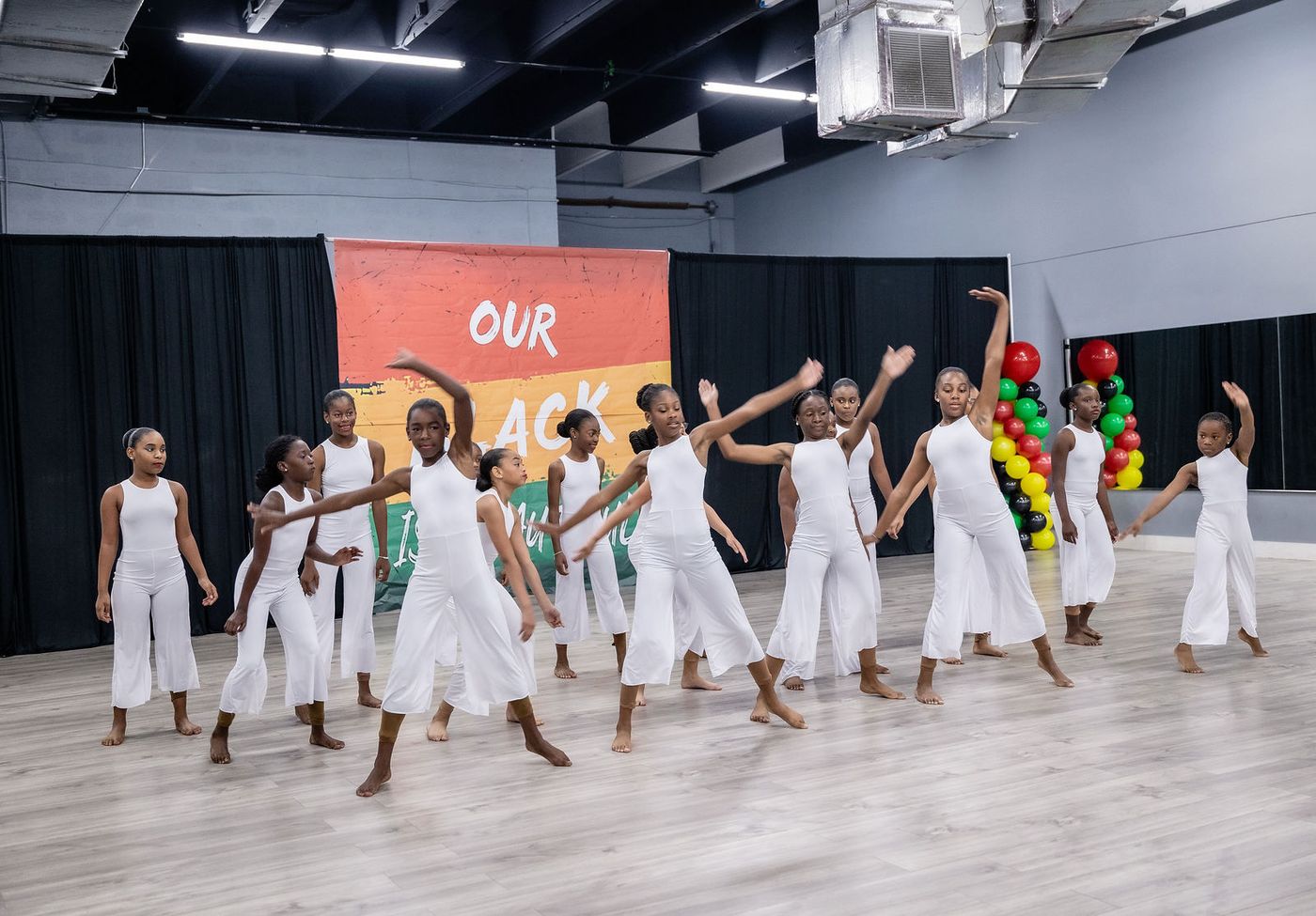 The full company performing together at a dance studio showcase