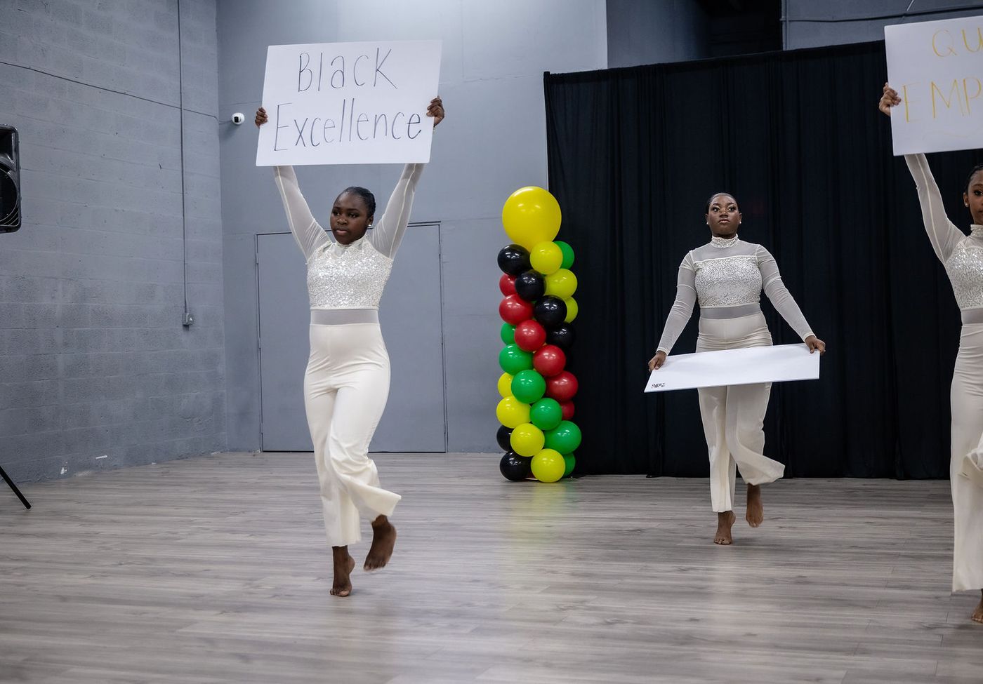 Dancers carrying hand-lettered signs during a Black History showcase