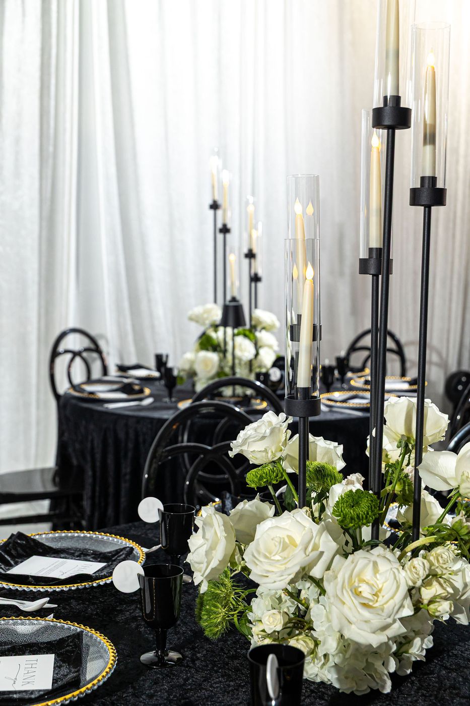 White roses and black candlesticks on a monochrome banquet table