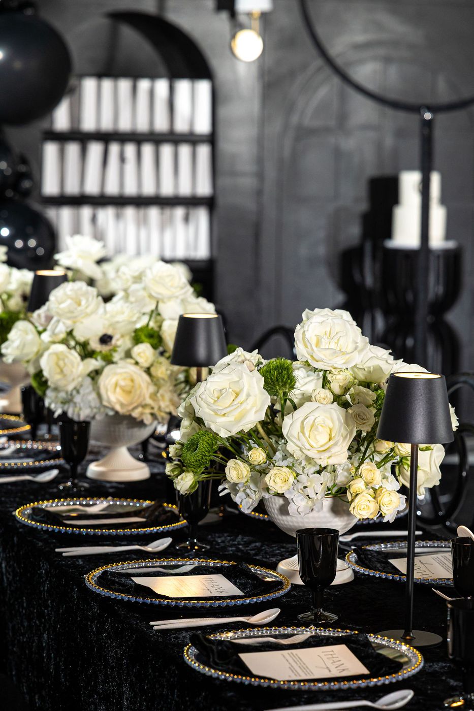 A monogrammed cake backdrop and black balloon garland