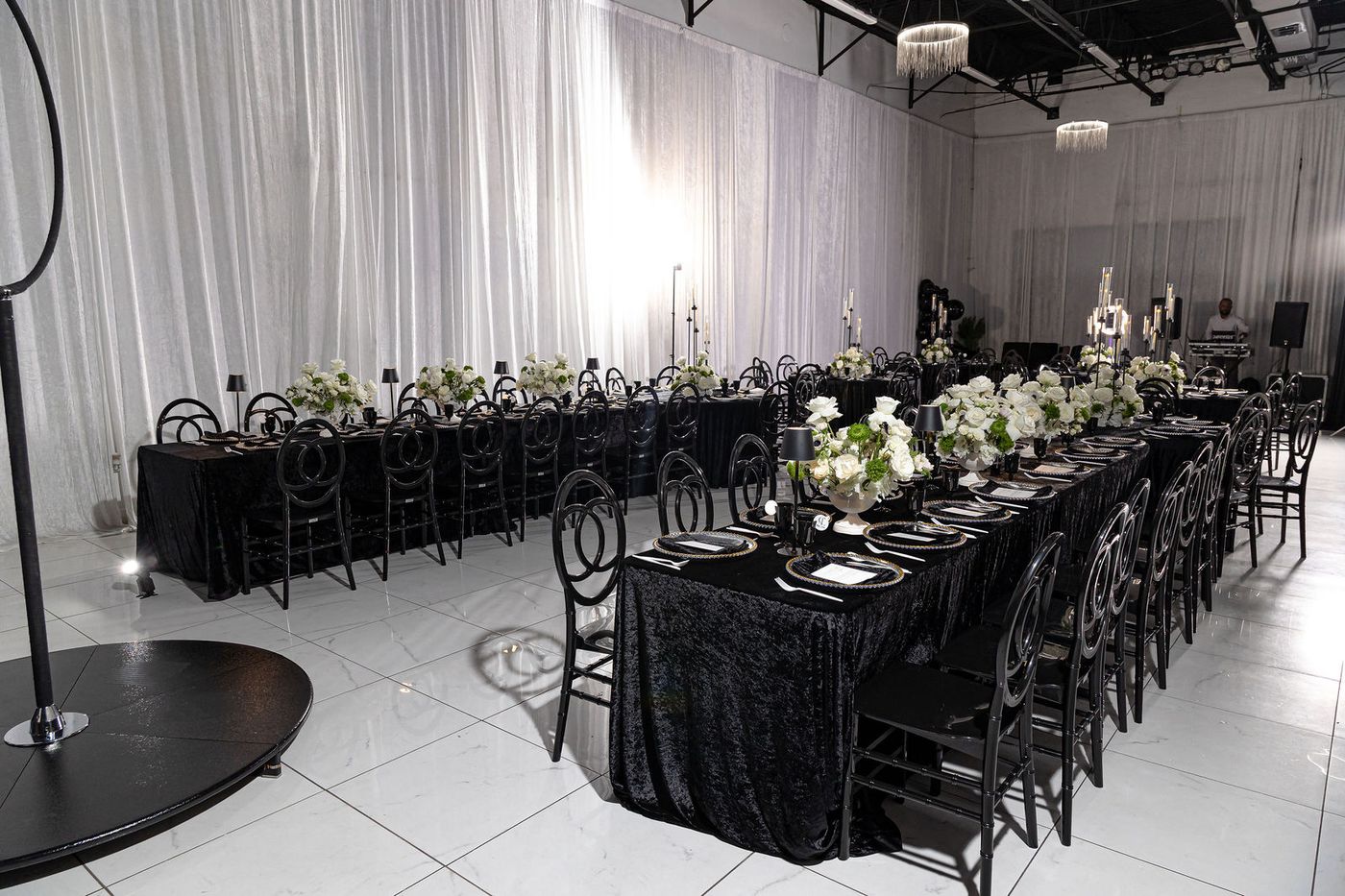 A long black velvet banquet table set for a monochrome milestone birthday