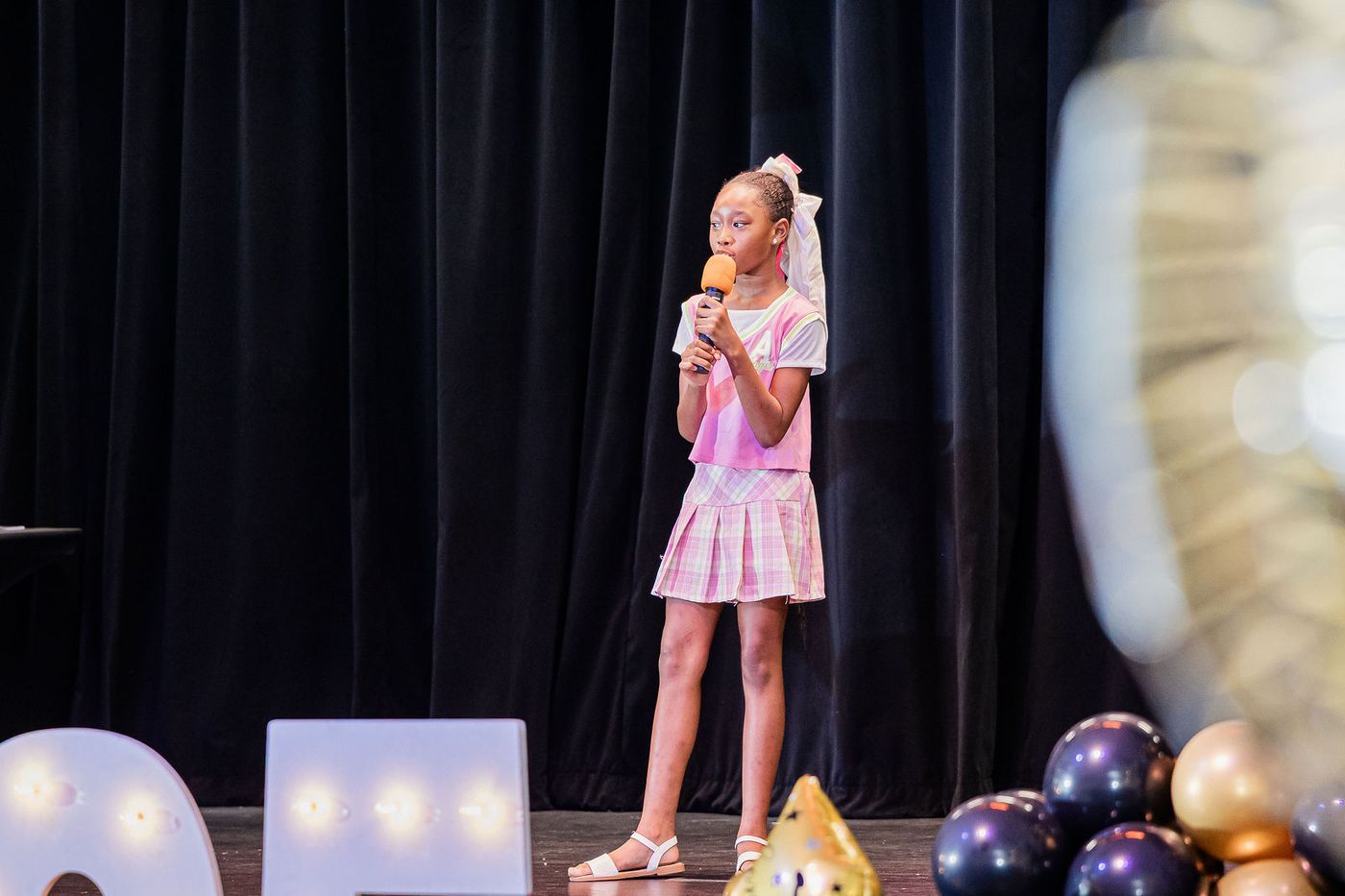 A child soloist performing at a school graduation ceremony