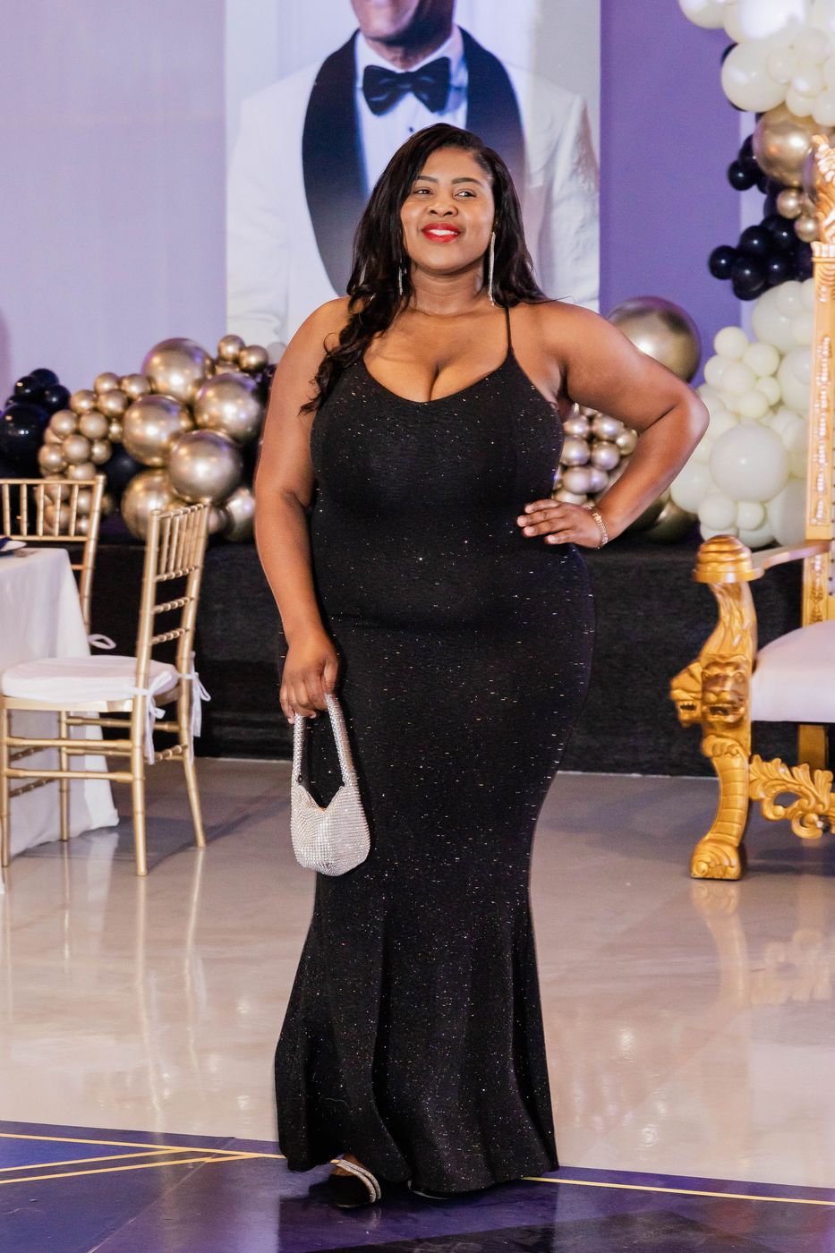 A guest in a beaded black gown on the portrait riser
