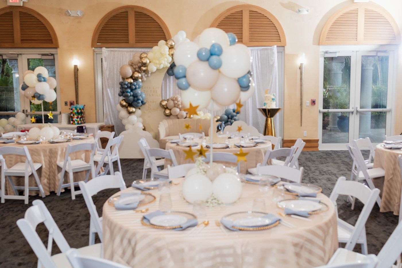 A baby shower room laid in blue, cream and gold