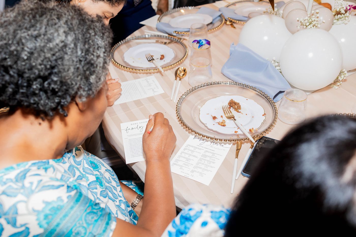 A guest writing the place cards before a baby shower