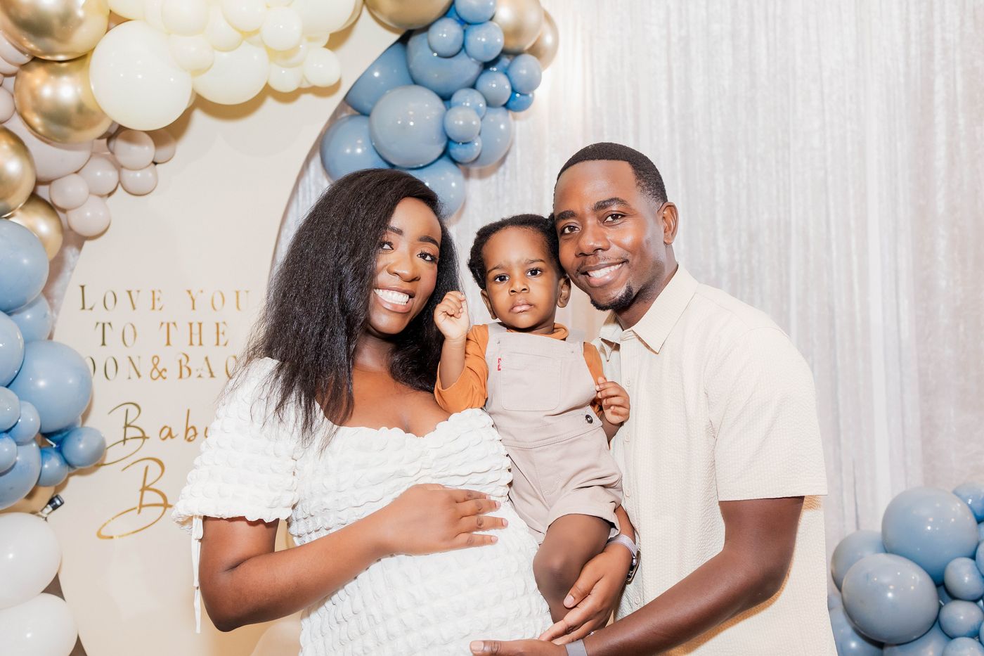 The parents-to-be photographed with their son at the arch