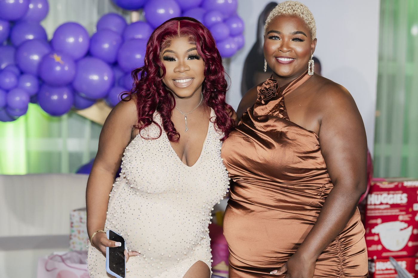 Two guests photographed at the baby shower arch