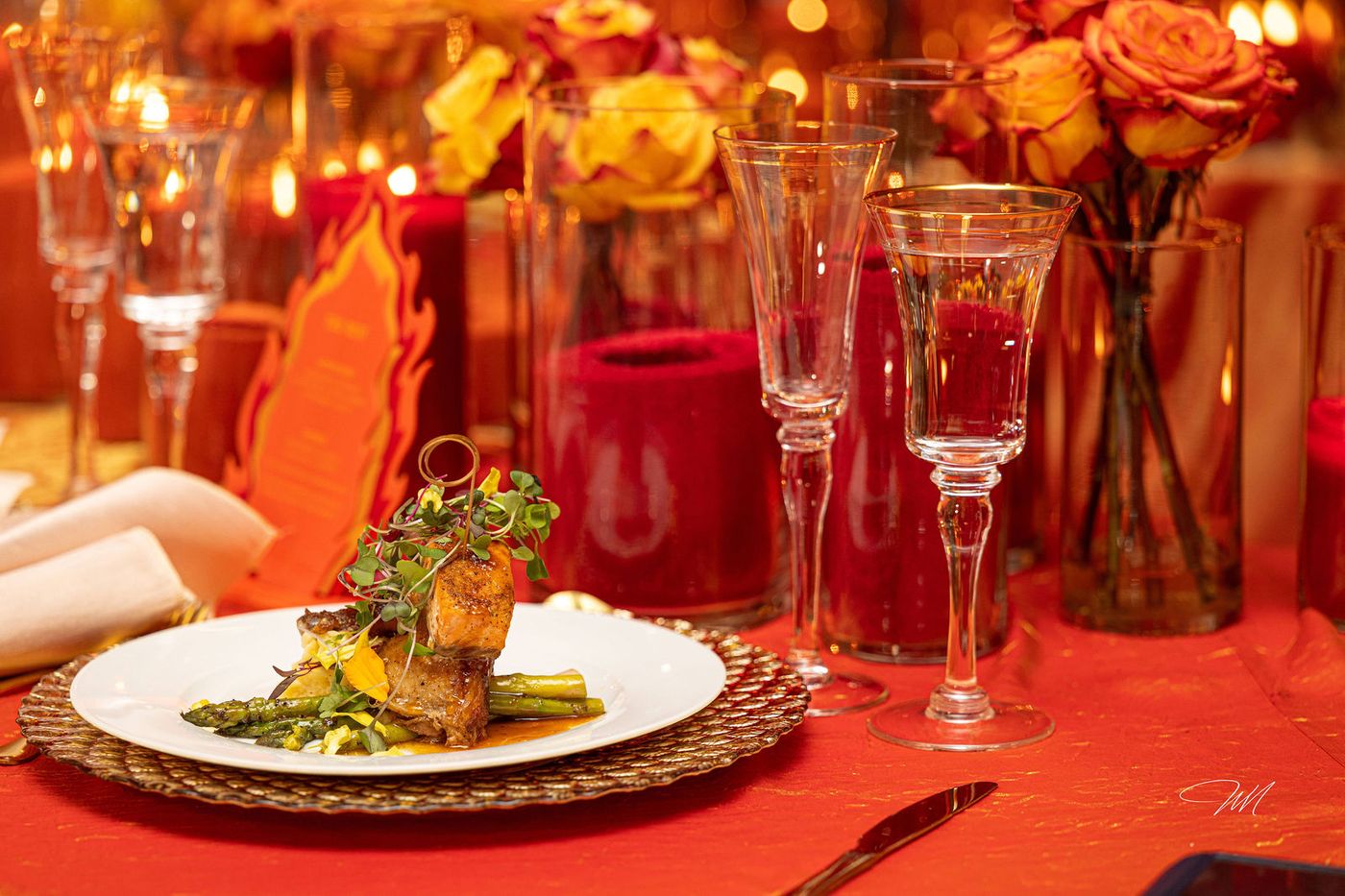 A plated dinner service photographed across a flame coloured tablescape
