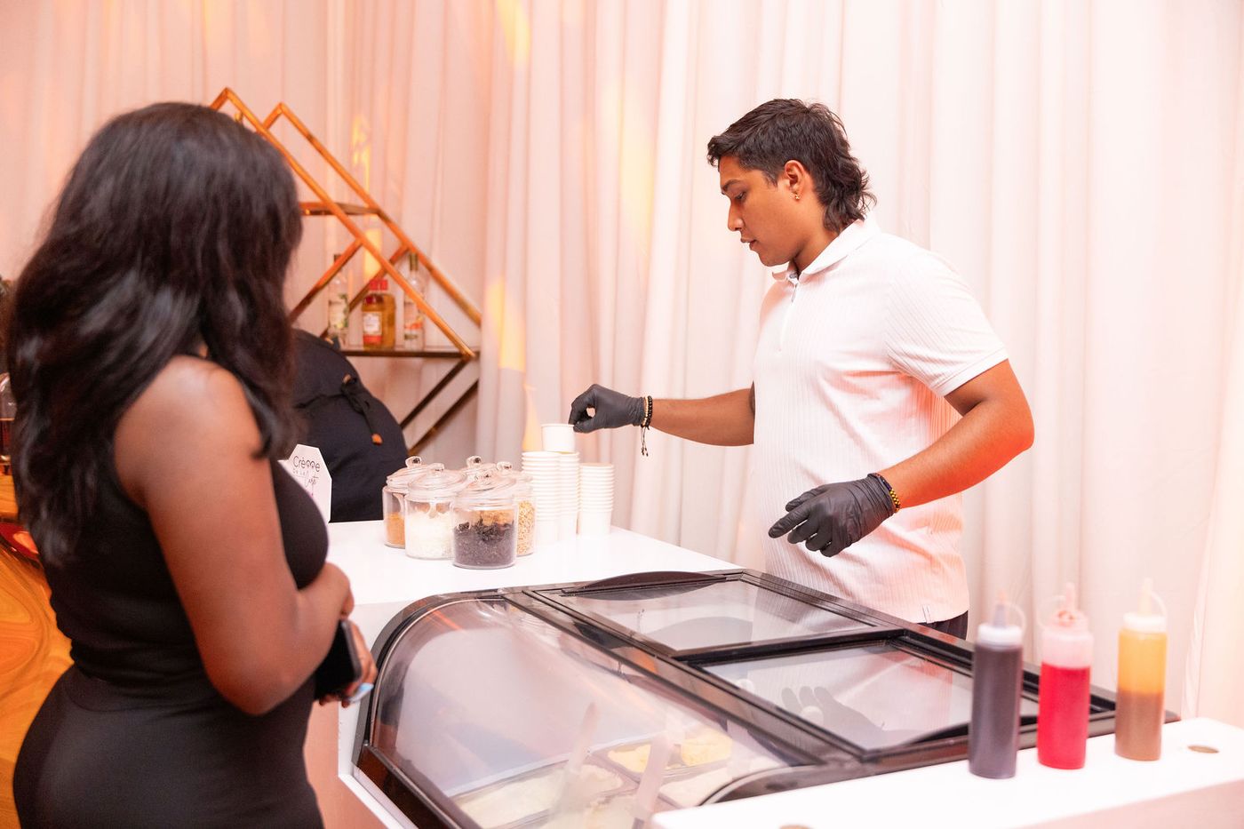 A guest served from a dessert cart on the floor of an evening celebration