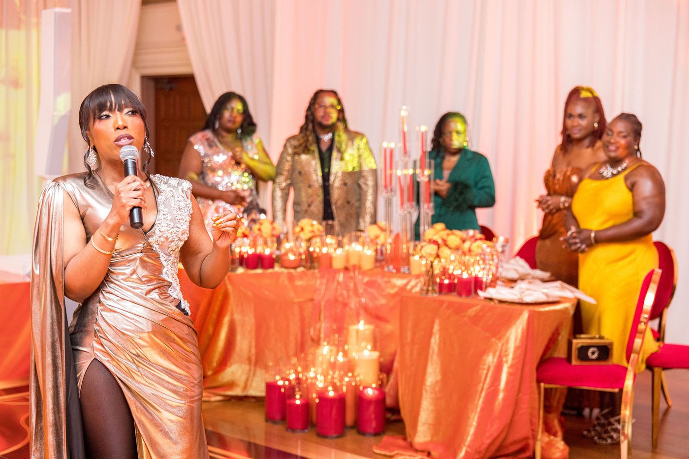 The host speaking beside the candlelit head table of a flame themed gala