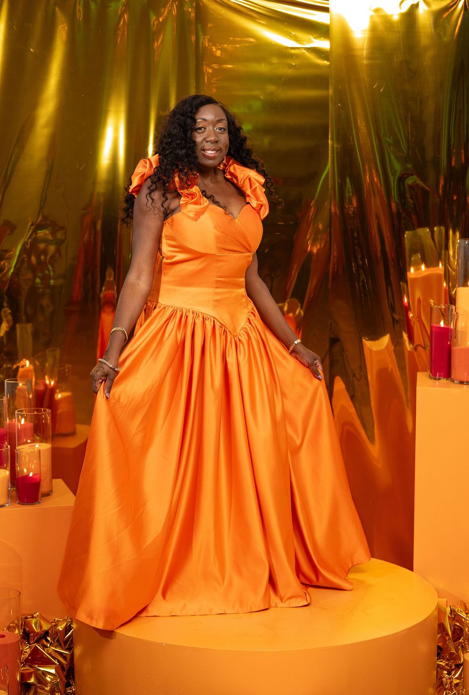 A guest in a scarlet satin gown photographed on the portrait riser