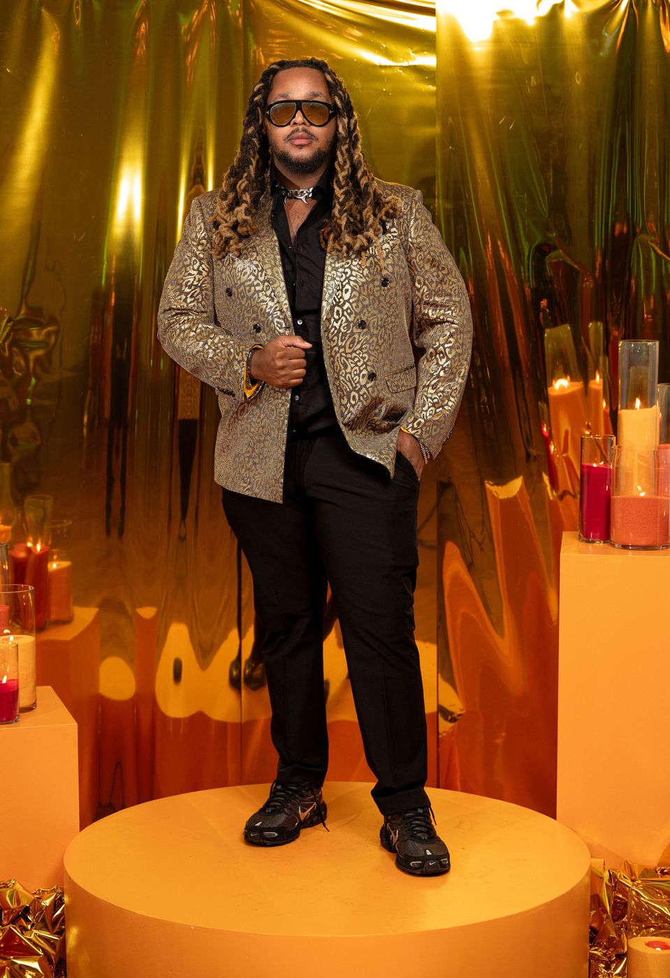 A guest in a brocade jacket photographed at the gold foil portrait station