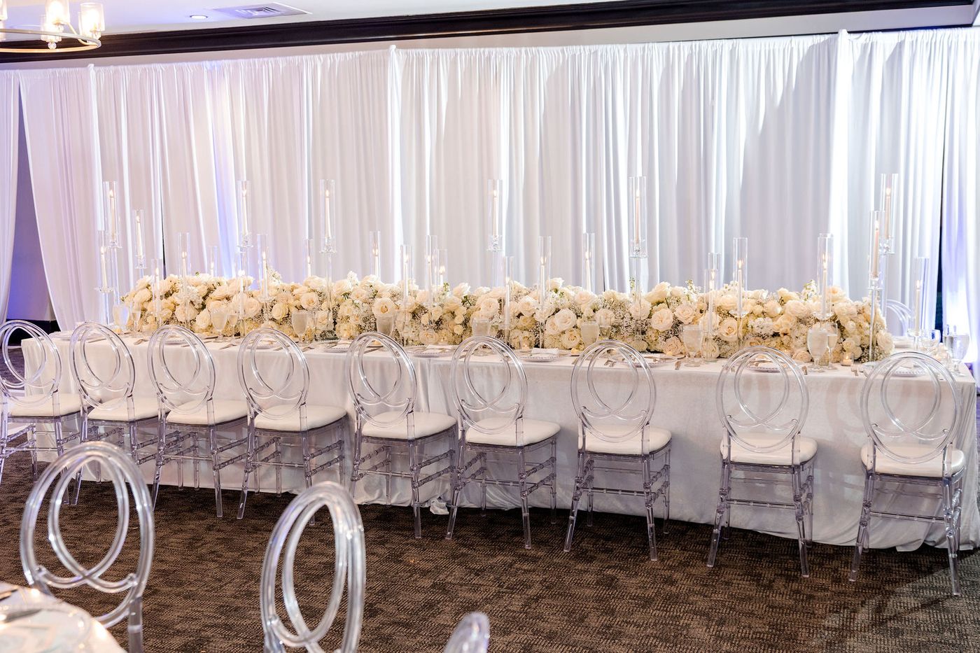 A floral runner of white roses and hydrangea along the head table of a South Florida anniversary gala