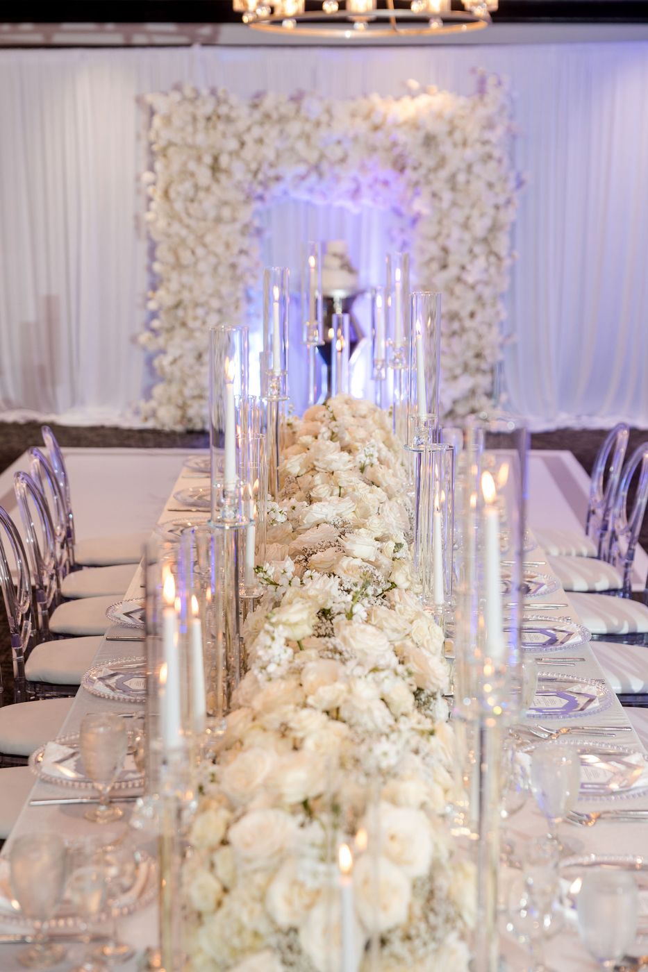 A floral tower of white roses rising from the centre of a long anniversary table