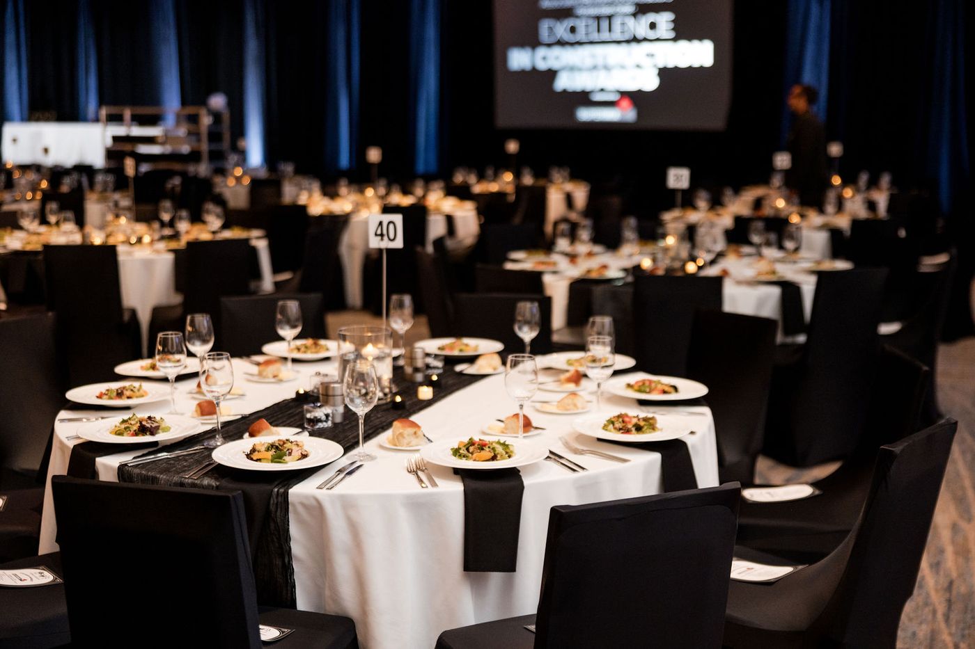 Forty banquet tables laid in black and white, photographed before the doors open