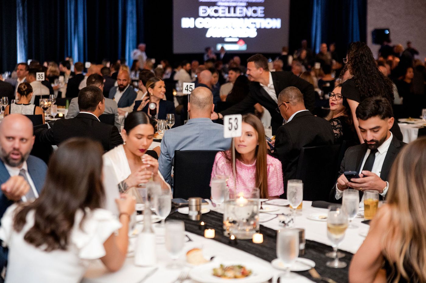 The view from a guest table across a full ballroom during an awards banquet programme