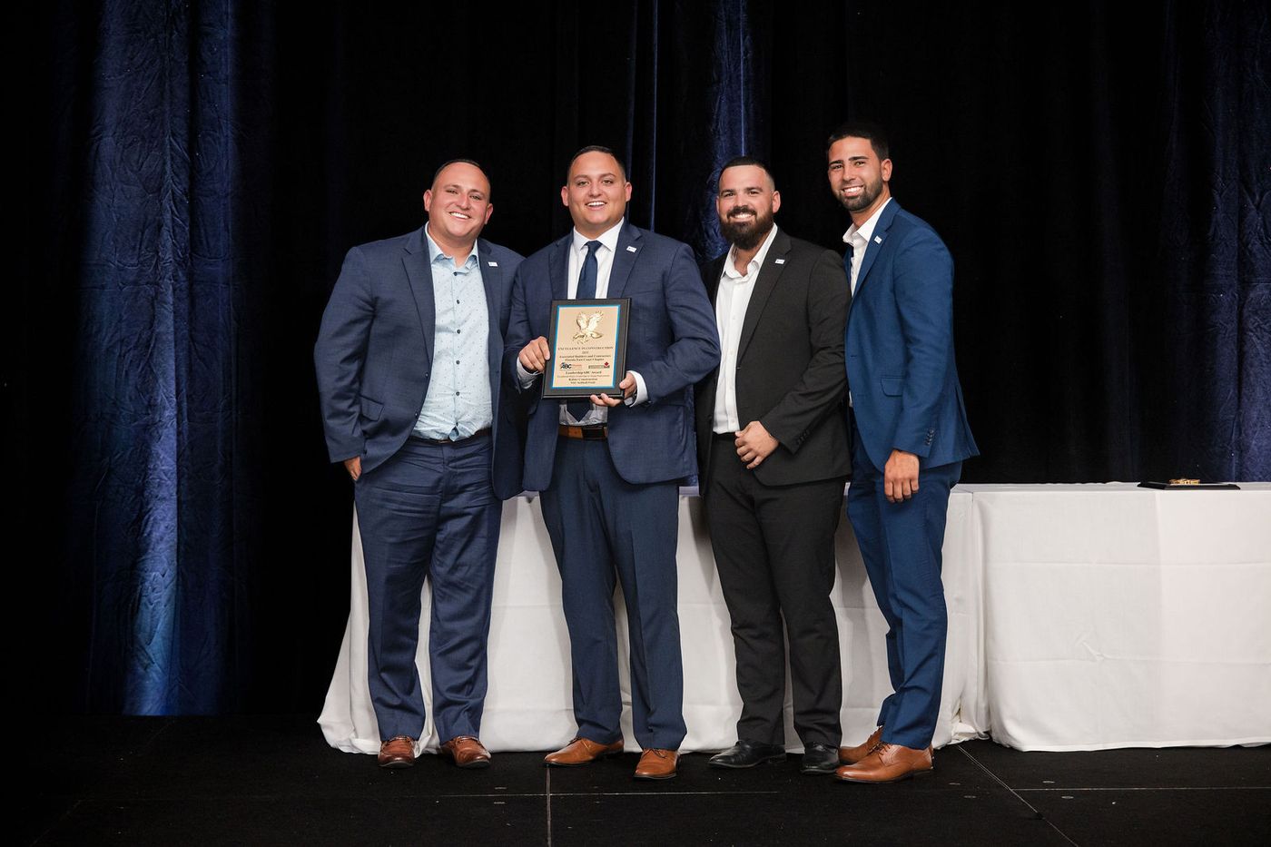 A winning team photographed on stage with their award